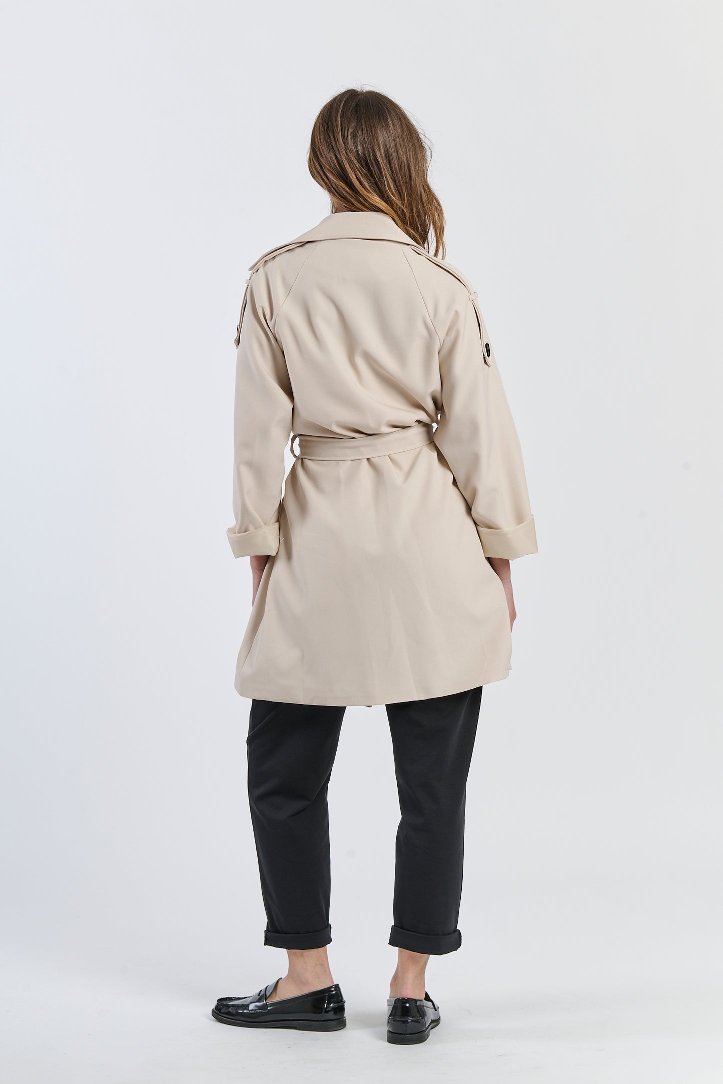 Trench beige a lunghezza media, design sartoriale per un’eleganza sobria.