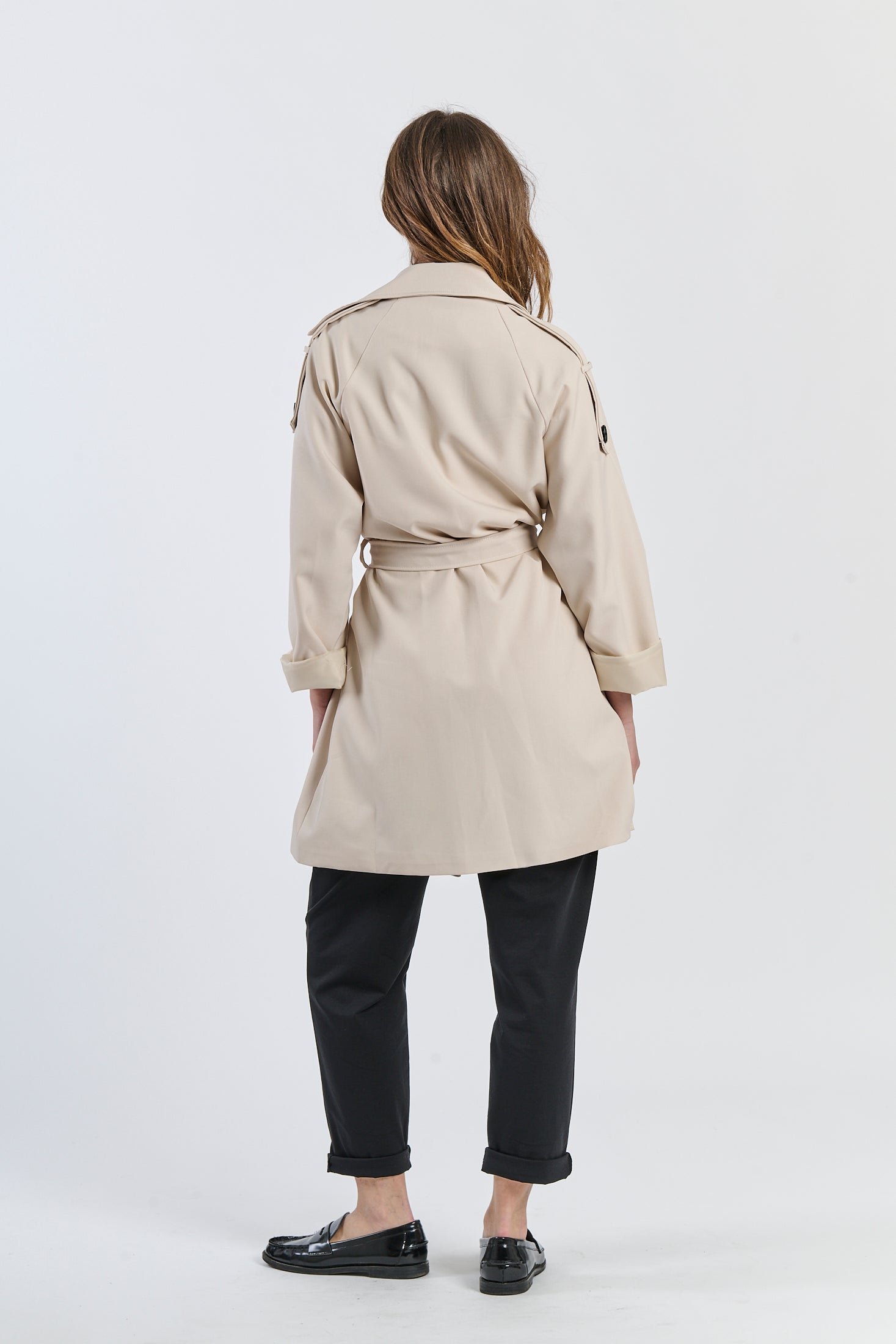 Trench beige a lunghezza media, design sartoriale per un’eleganza sobria.