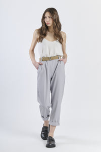 Outfit con top satinato rosa e pantaloni grigio chiaro, contrasto rinfrescante