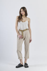 Outfit con top satinato rosa e pantaloni beig, cinghia in tonalità calda