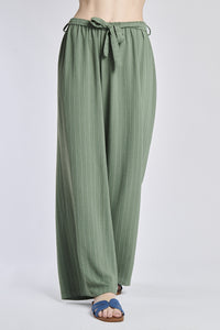 Pantaloni larghi militari con coulisse e nodo in vita, abbinati a sandali.