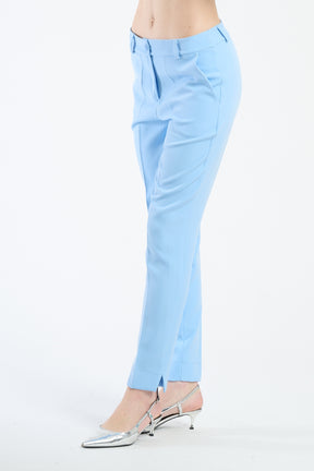 Pantaloni azzurri in tessuto lucido, abbinati a scarpe argento.