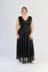 Abito nero da cerimonia, colletto a V e gonna fluviale, eleganza assoluta.