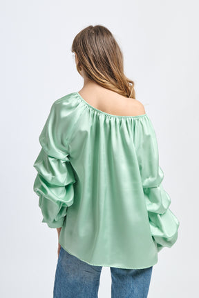 Blusa verde menta in seta, spalle scoperte, maniche volanti, atmosfera rinfrescante