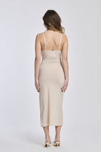 Abito beige a spalline sottili, tessuto fluido e apertura laterale per un look elegante.