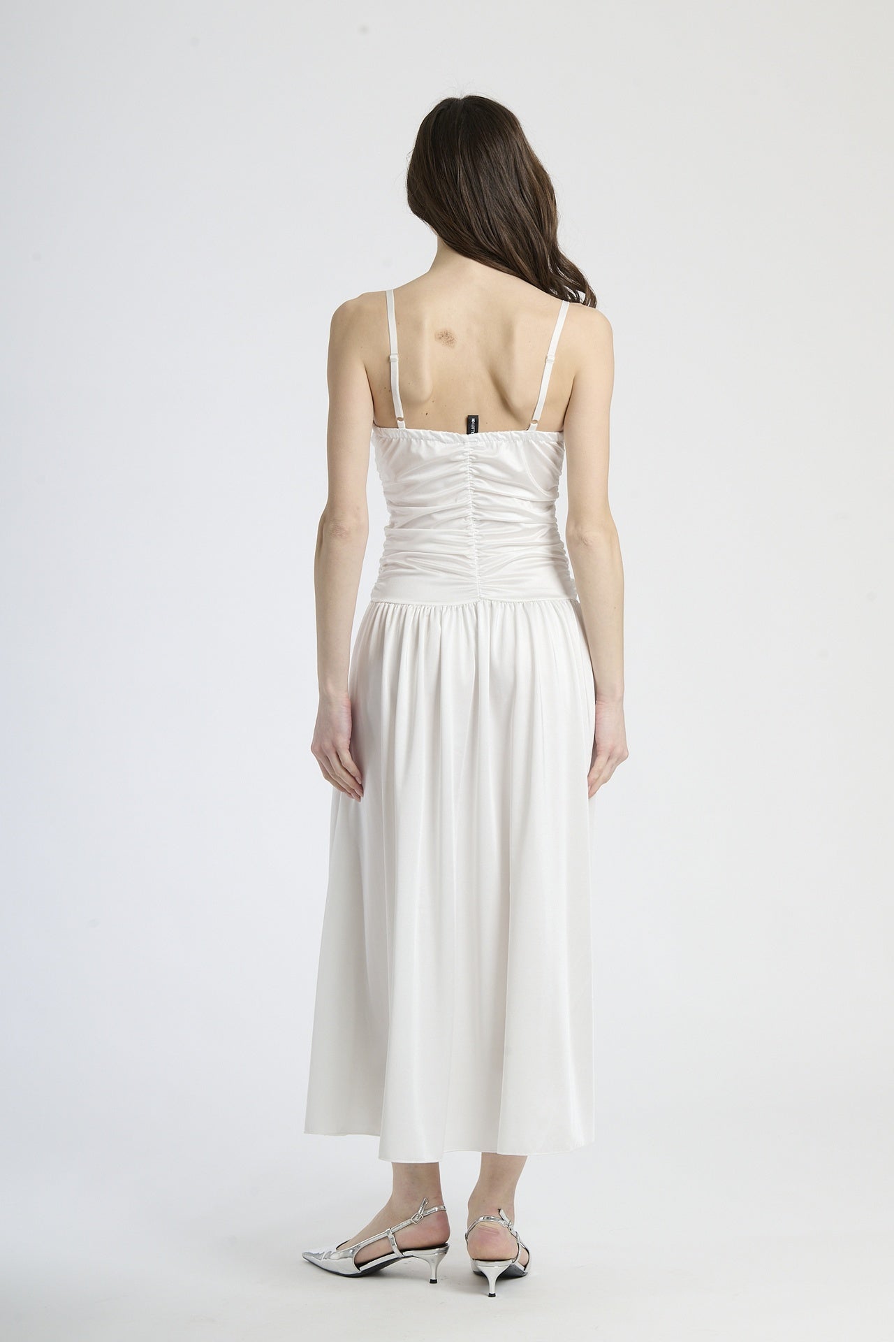 Vestito bianco in tessuto luminoso, taglio maxi con scollatura a V, perfetto per matrimoni e eventi estivi.