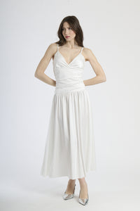 Abito lungo bianco con scollatura a V profonda, silhouette dritta e gonna fluttuante.