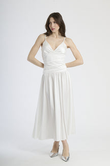 Abito lungo bianco con scollatura a V profonda, silhouette dritta e gonna fluttuante.