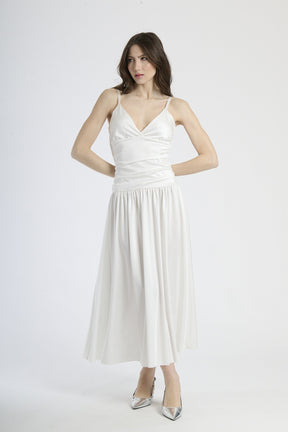Abito lungo bianco con scollatura a V profonda, silhouette dritta e gonna fluttuante.