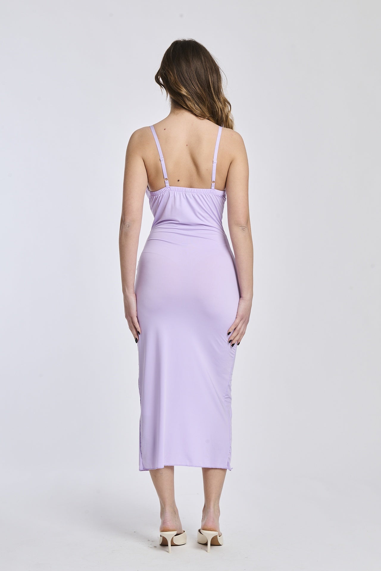 Abito lilla a spalline sottili, tessuto leggero e apertura laterale per uno stile delicato e affascinante.