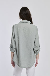 Camicia oversize militare, stile rustico, bottoni frontali, maniche arrotolate.