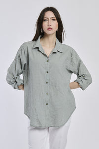 Camicia militare a righe, collo camiciera, maniche a 3/4, abbinata a pantaloni chiari.