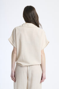 Outfit casual beige, camicia a maniche corte con stampa e pantaloni ampi