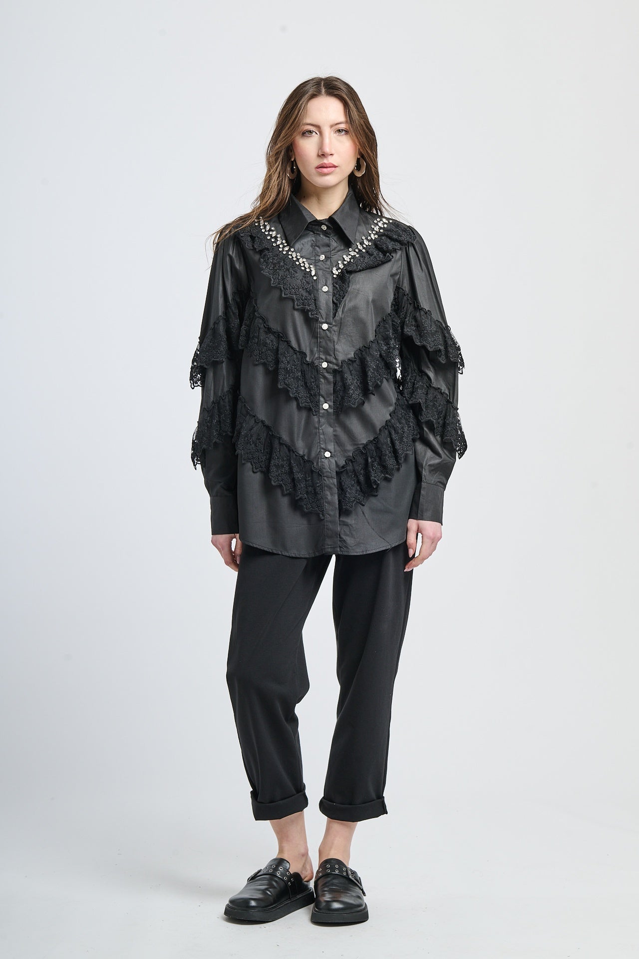 Camicia di stile moderno per donne, con maniche a tromba e dettagli di pizzo e chiodini.