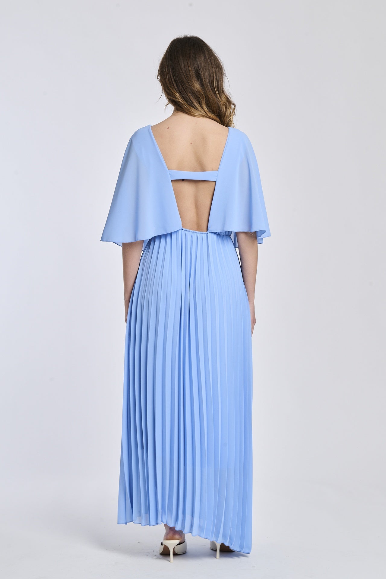 Un abito azzuro che presenta la stessa croce sul petto e la falda fluttuante, creando un'atmosfera di romantismo e giovinezza.