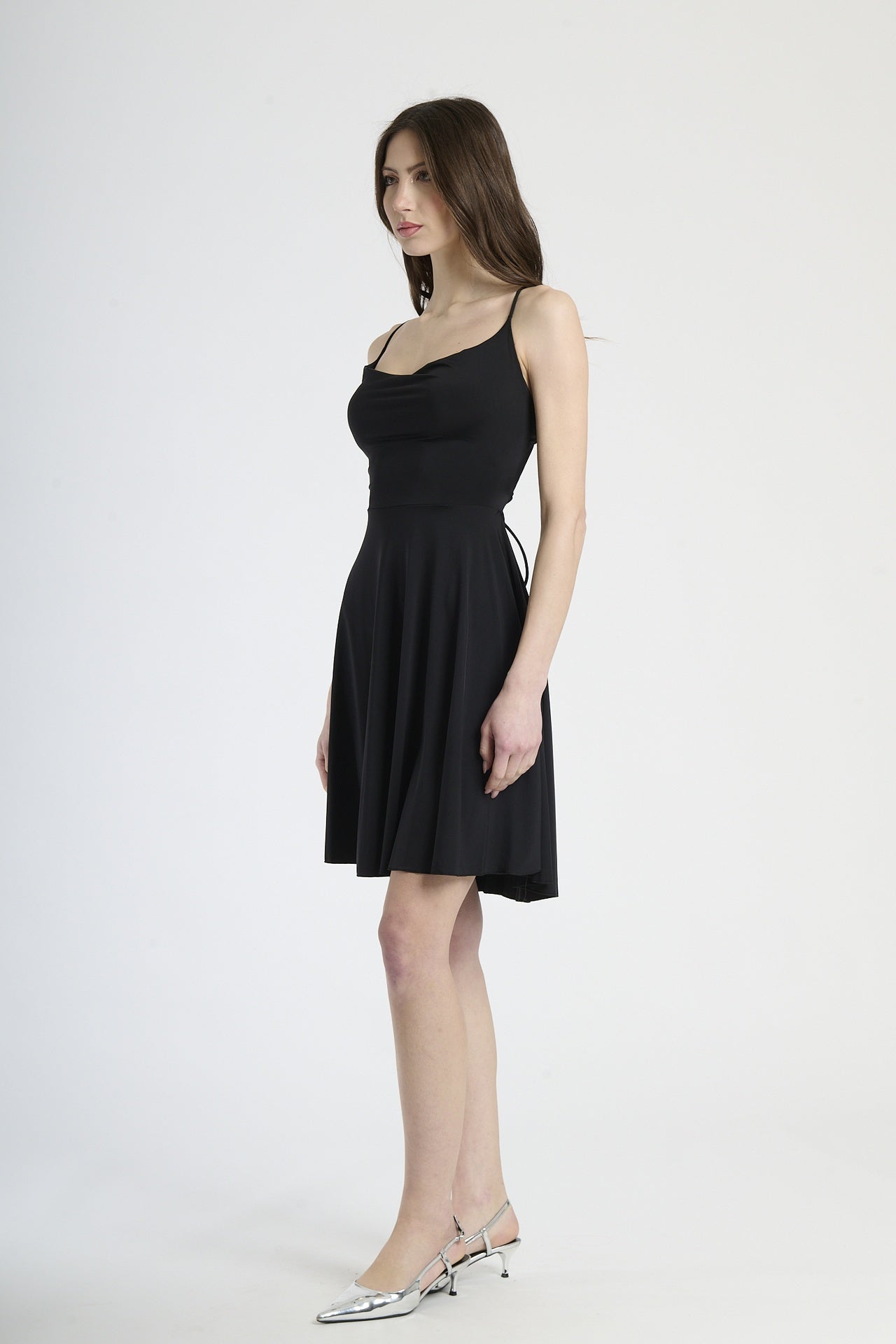 Moda donna: abito nero corto, design con bretelle sottili e colletto avvolgente, perfetto per un look classico e affascinante.