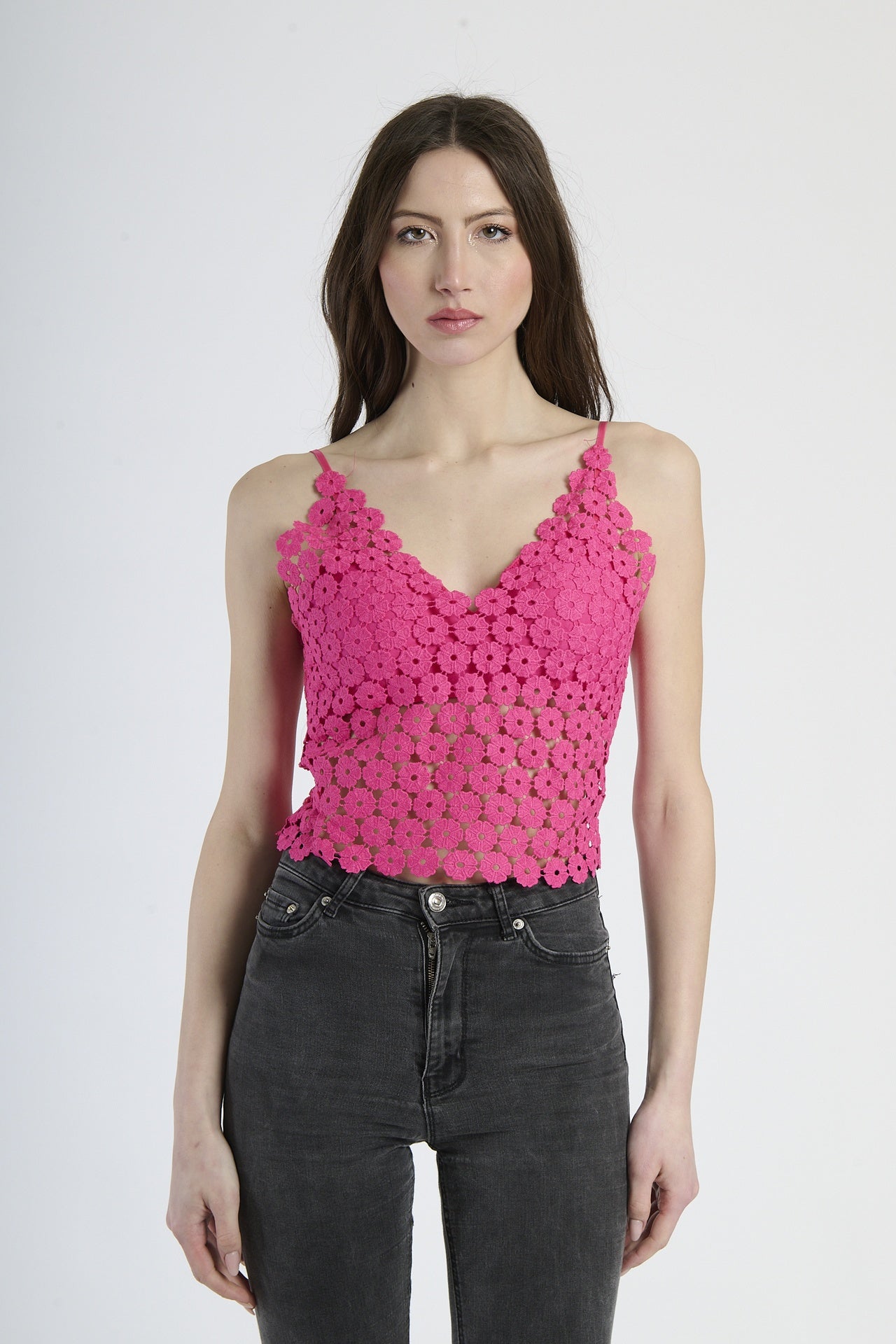 Top cropped fuxia a uncinetto, con scollatura a V e bretelle sottili, stile vivace.