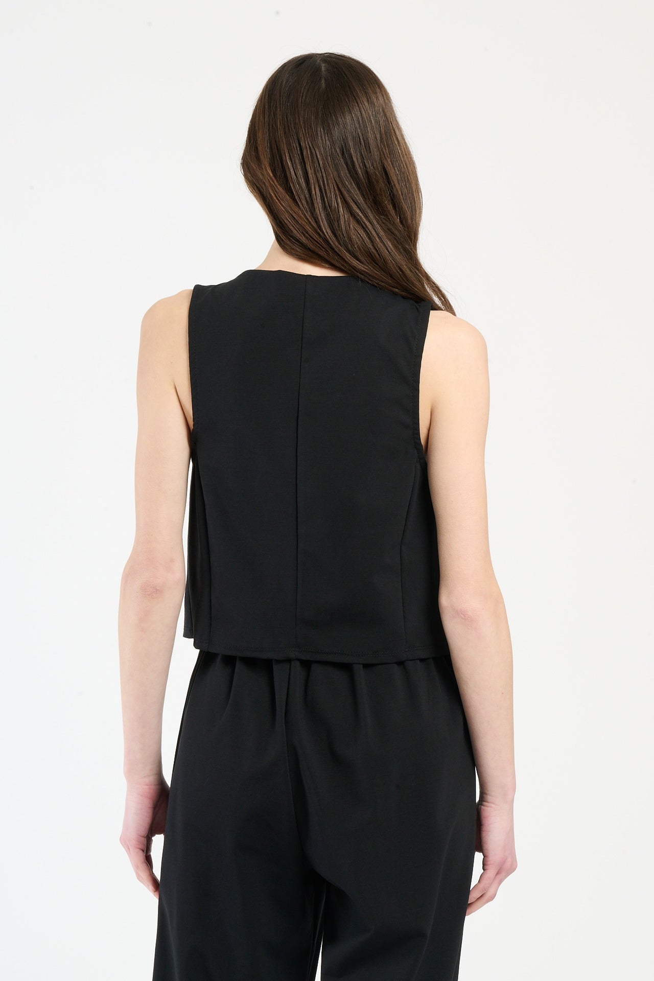 Donna con completo nero: gilet e pantaloni, eleganza atemporale e sophisticated.