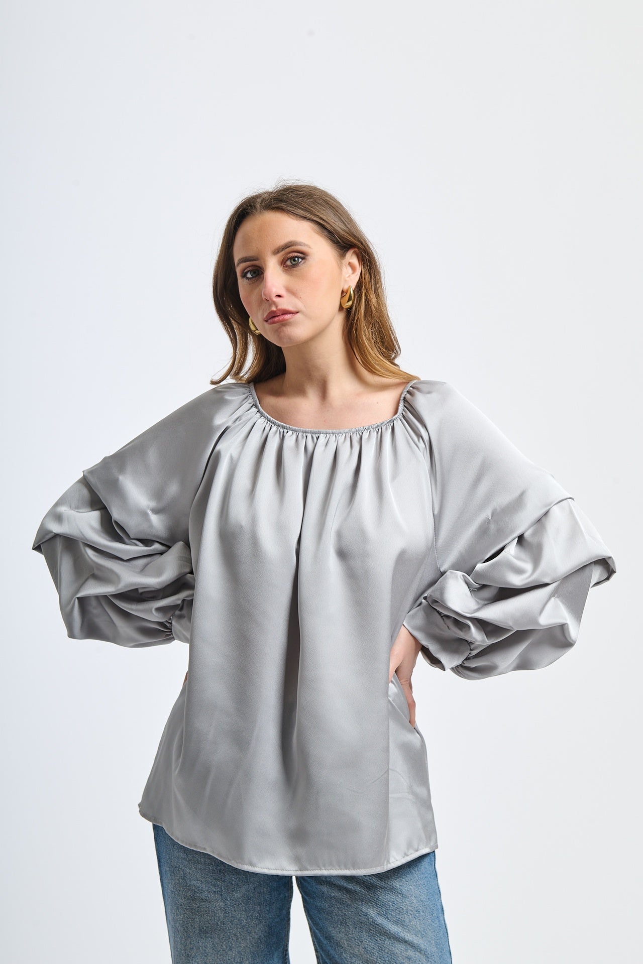 Blusa grigia in seta, spalle scoperte, maniche volanti, atmosfera minimal