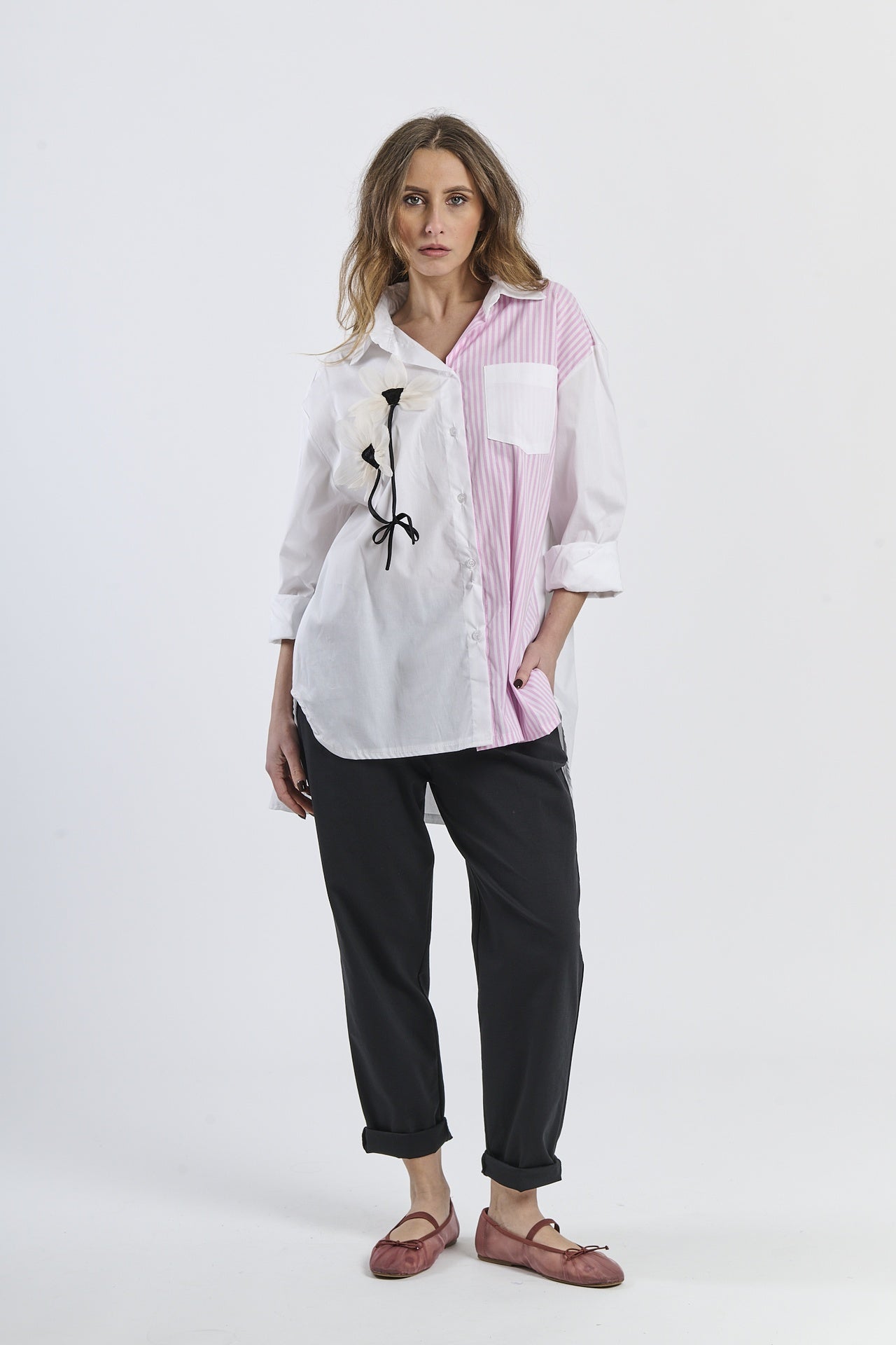 Outfit casual con camicia a righe bianco-rosa asimmetrica, dettaglio floreale e pantaloni marroni, scarpe mocassini rame