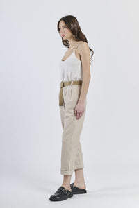 Look con top senza maniche rosa e pantaloni beig ampi, scarpe color cammello