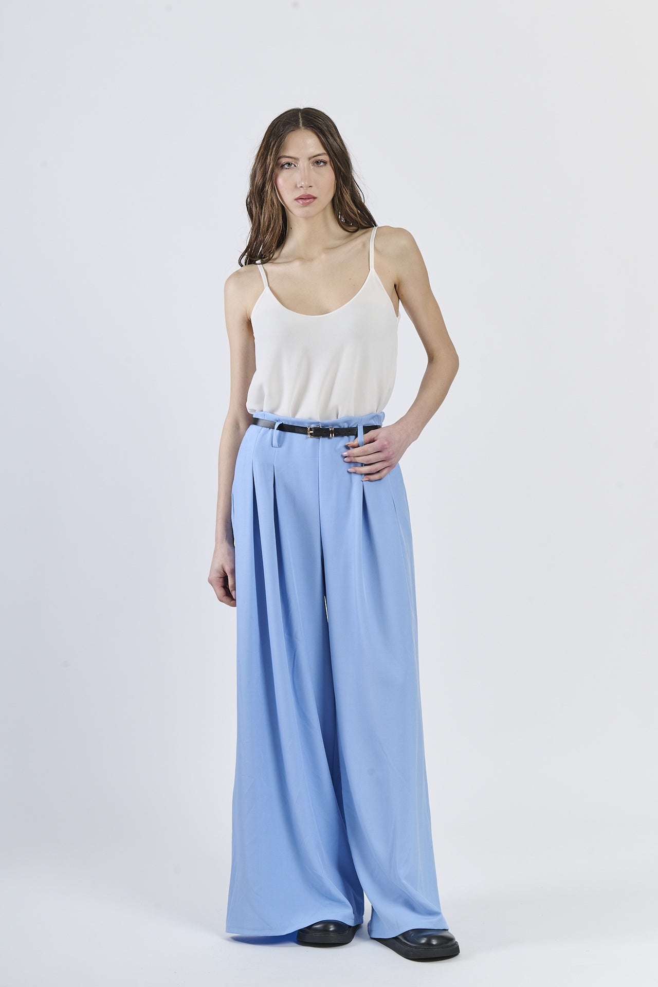 Combinazione top bianco e pantaloni azzurri fluide, stile minimal-chic