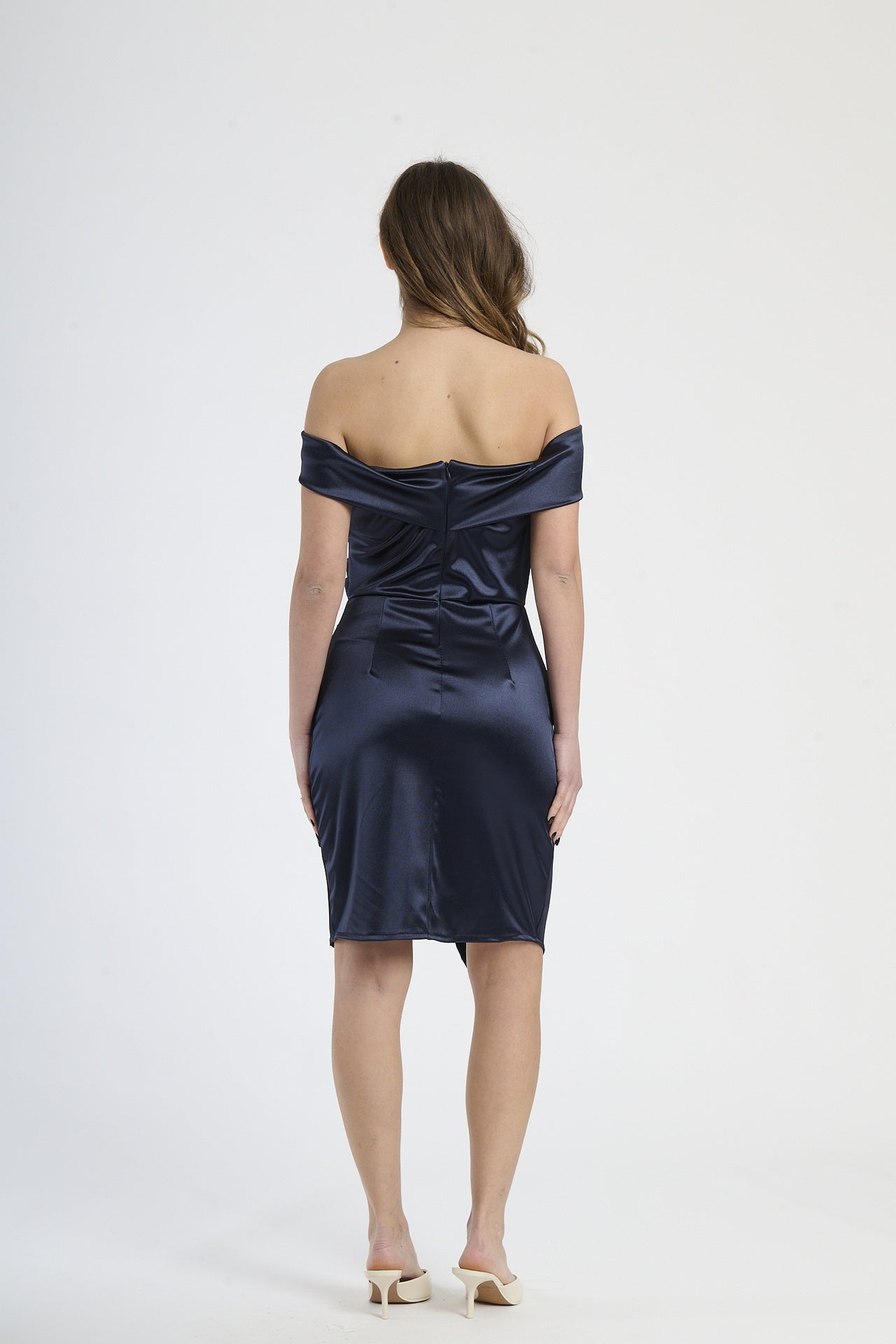 Modella in abito navy con plissé, stile preppy e sofisticato per serate formali.