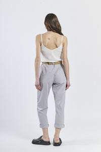 Combinazione top rosa lucido e pantaloni grigio chiaro, stile minimal-moderno