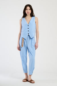 Modella in completo azzurro composto da gilet e pantaloni, perfetto per un look casual-chic.