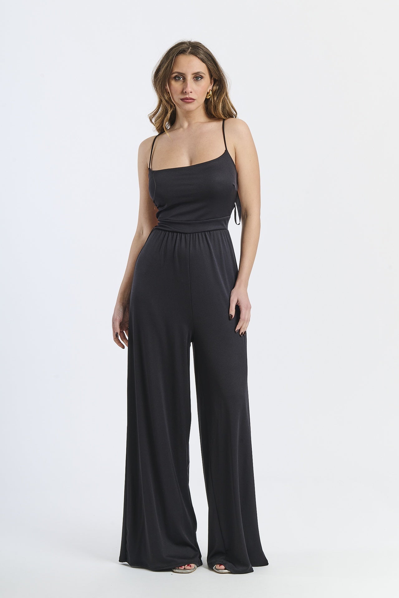 Tuta intera nera, spalline sottili, taglio ampio, stile iconico ed elegante