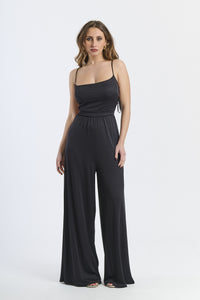 Tuta intera nera, spalline sottili, taglio ampio, stile iconico ed elegante