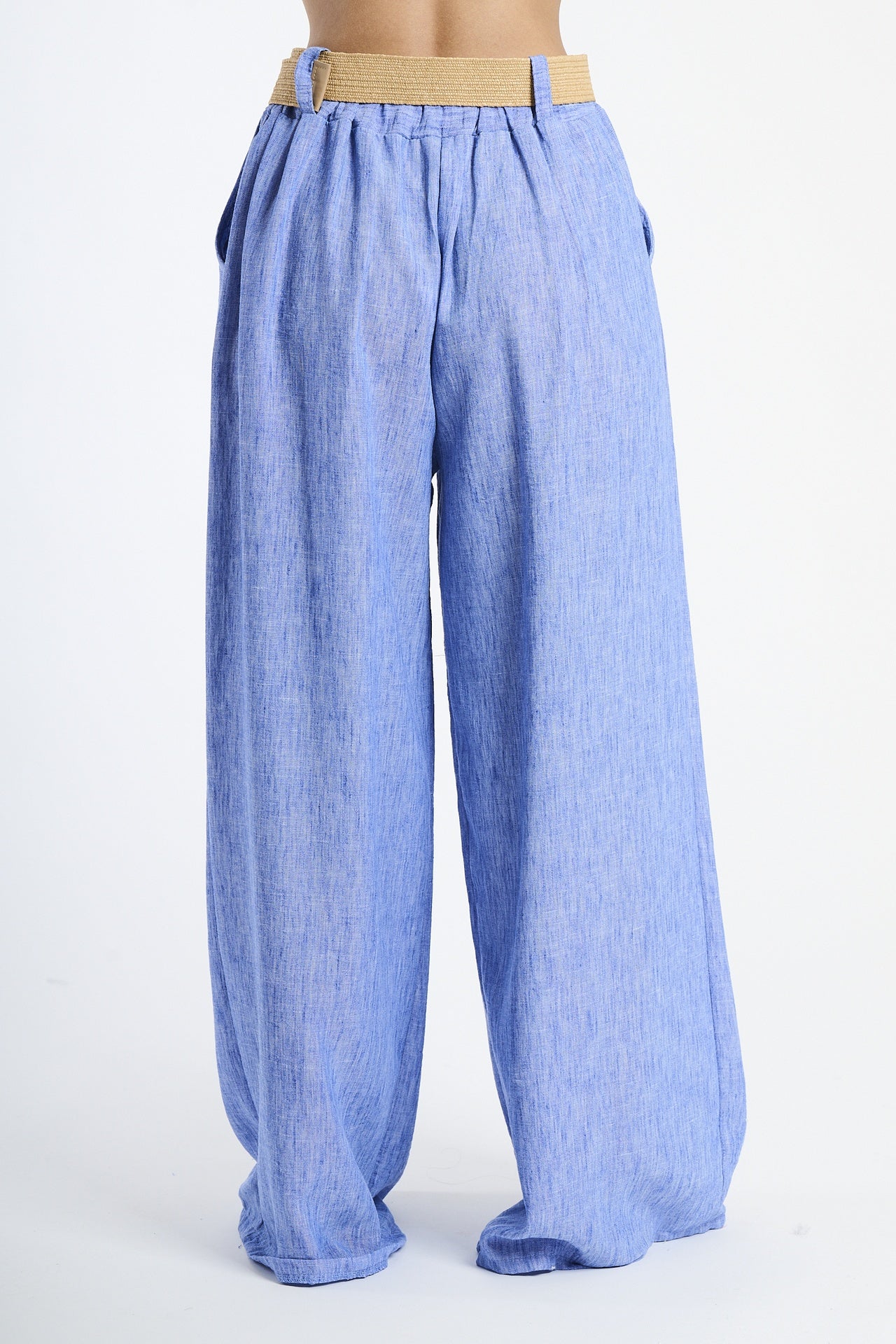 Modella in pantaloni bluette larghi, stile minimalista e accattivante.