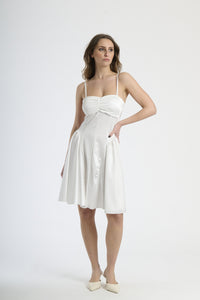 Abito bianco con dettagli plissettati, abbigliamento intemporaneo.