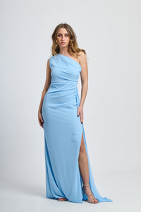 Abito lungo azzurro, spalla singola, drappeggio fluido, accessorio decorativo sulla spalla.