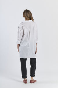 Outfit casual con camicia nero a righe bianco-rosa asimmetrica, dettaglio floreale e pantaloni marroni, scarpe mocassini rame