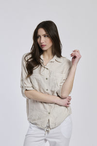 Camicia beige da donna con cuciture minimaliste, che dona un’eleganza sobria.