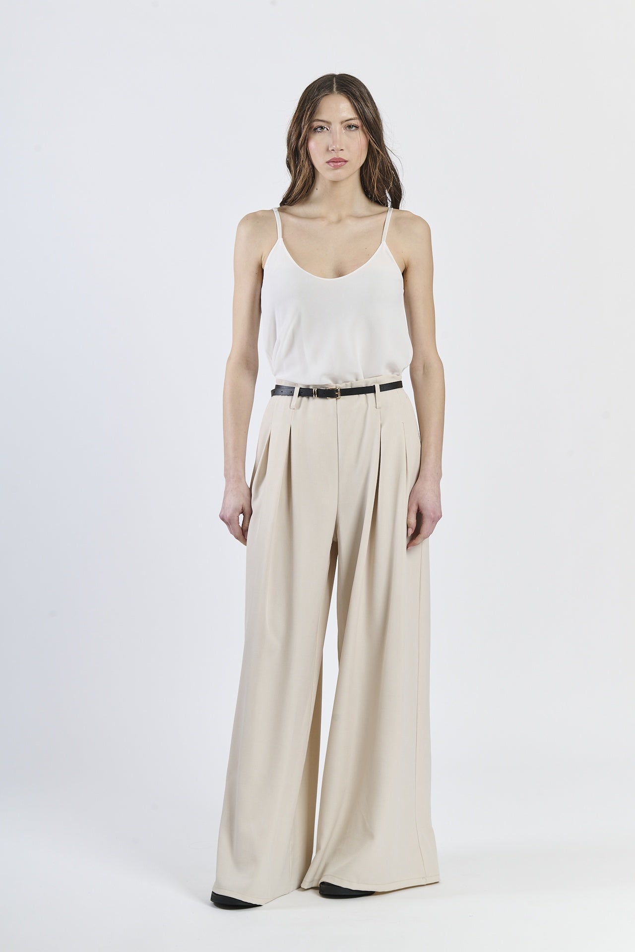 Look con top a bretelle sottili e pantaloni panna a gamba larga