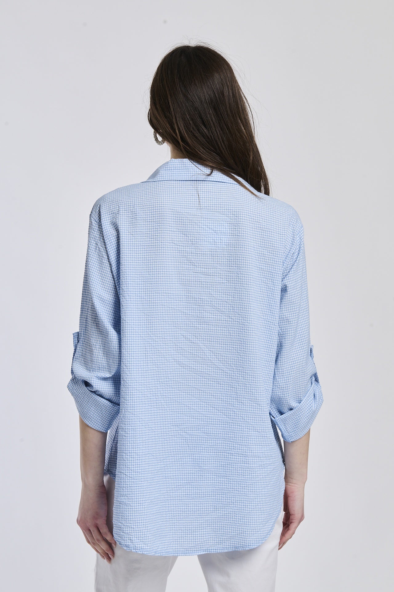 Camicia oversize azzurra, stile casual, bottoni frontali, maniche arrotolate.