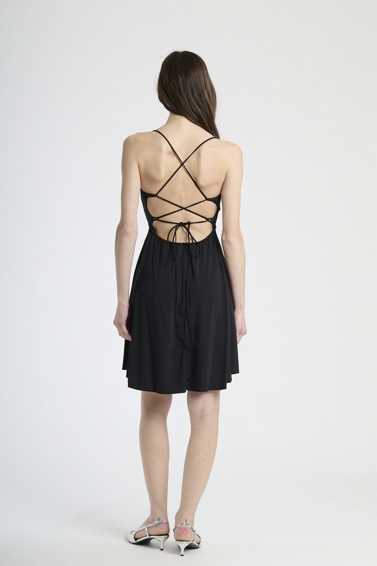 Vestito nero in tessuto liscio, silhouette a campana con bretelle sottili, ideale per eventi estivi notturni e occasioni formali leggere.