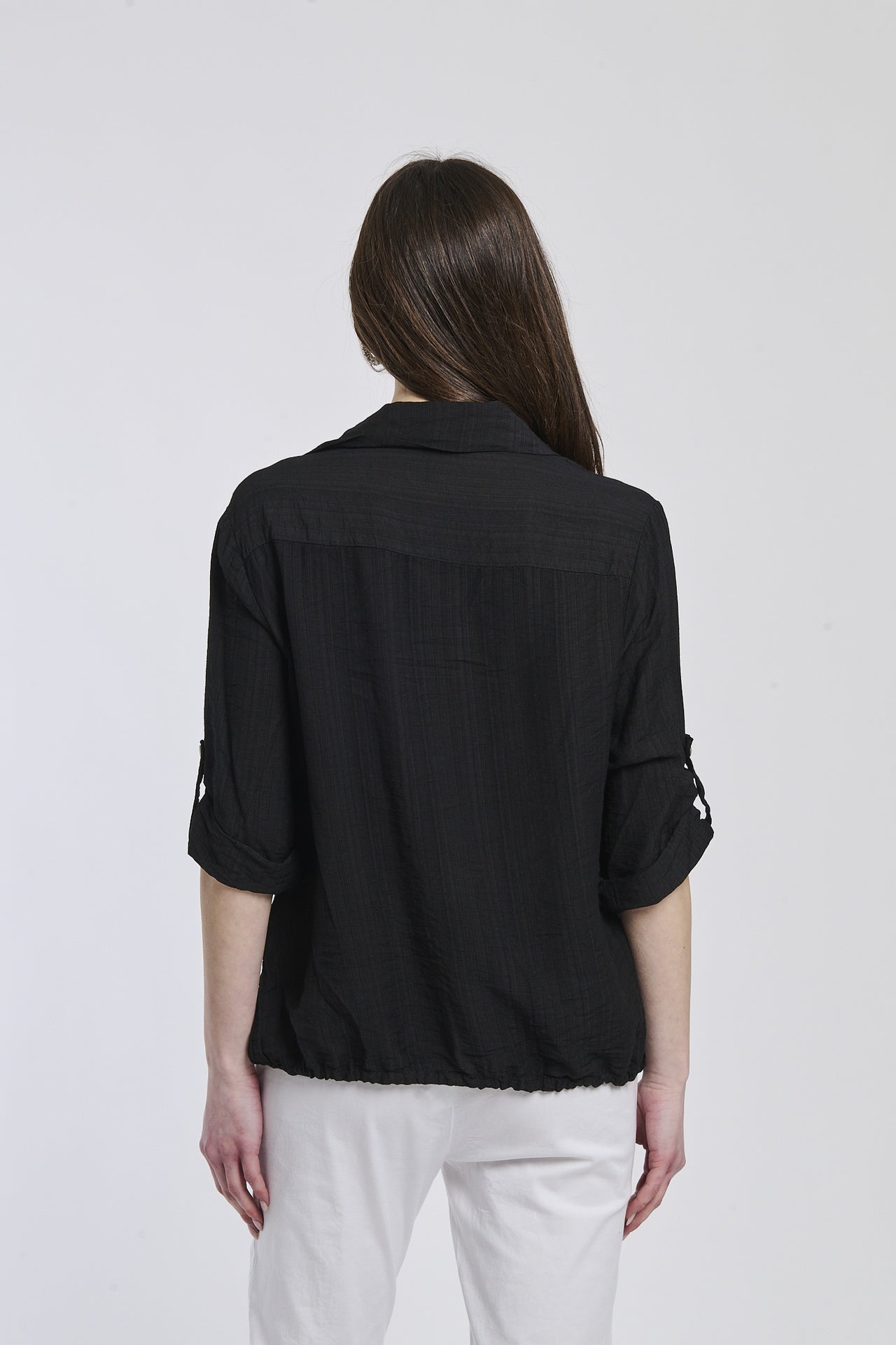 Donna con camicia nera di seta, che dona un’eleganza rinfrescante.