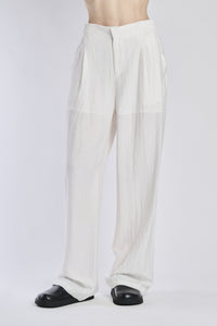 Pantaloni larghi bianchi, tessuto leggero, vita alta e ampie gamba, abbinati a mocassini 