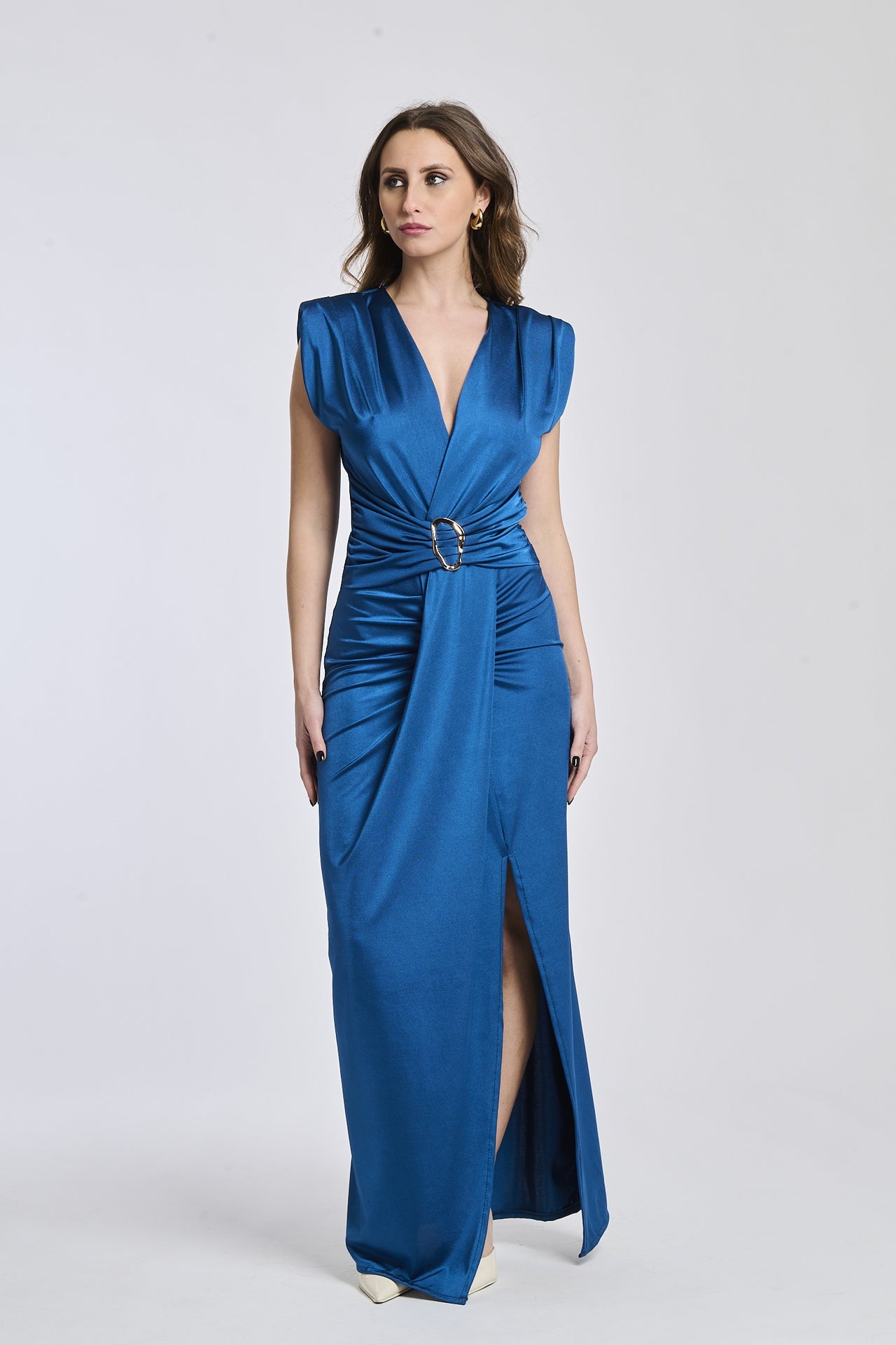 Donna indossa un abito lungo Ottanio, scollatura V, senza maniche e fascia in vita con fibbia.