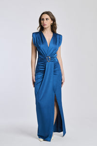 Donna indossa un abito lungo Ottanio, scollatura V, senza maniche e fascia in vita con fibbia.
