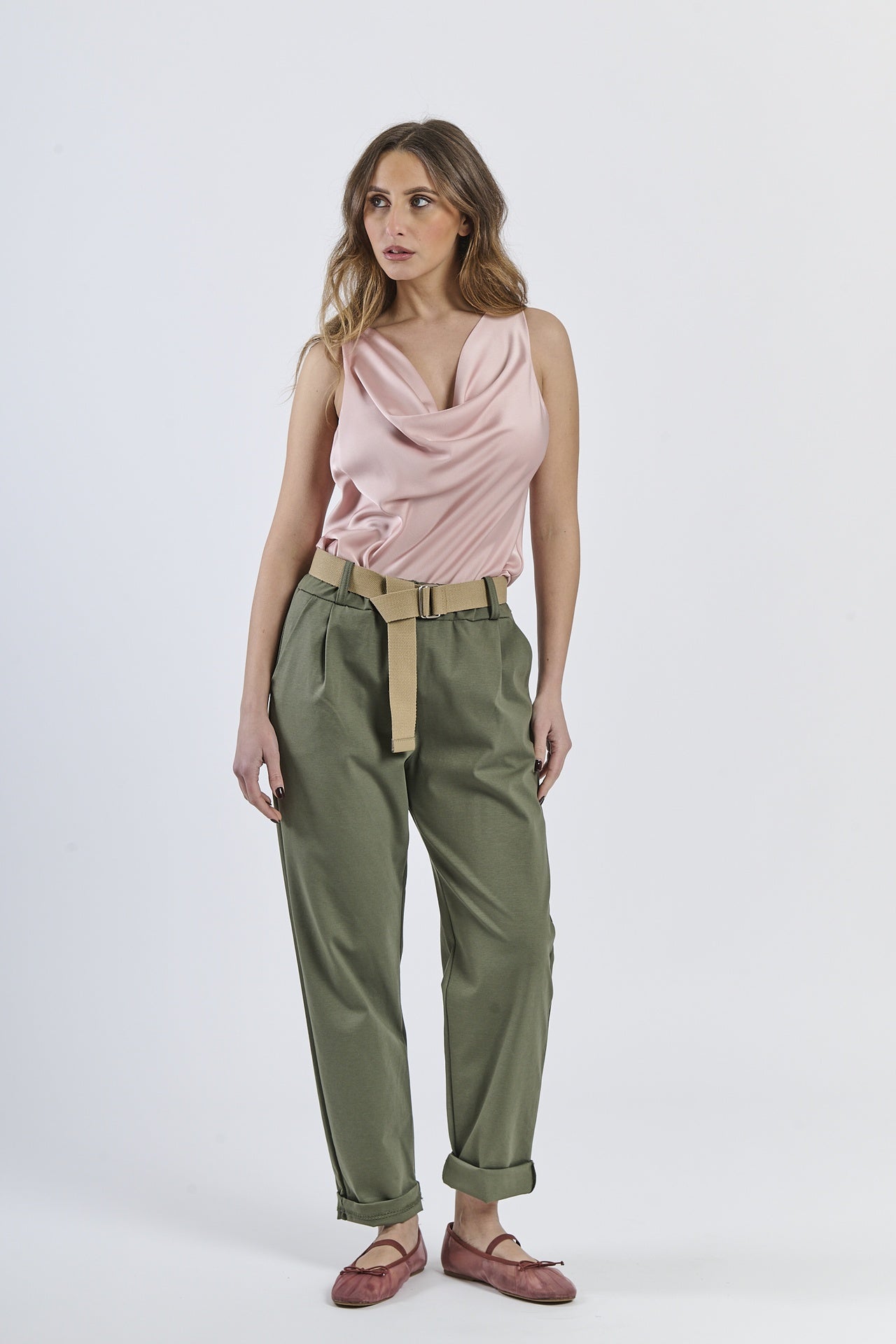 Look con top senza maniche rosa e pantaloni a taglio dritti color militare