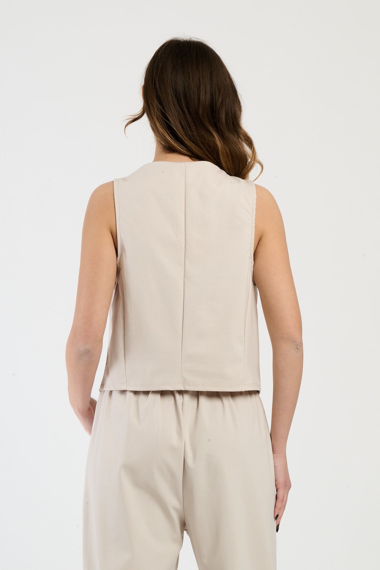 Donna con completo beige: gilet e pantaloni