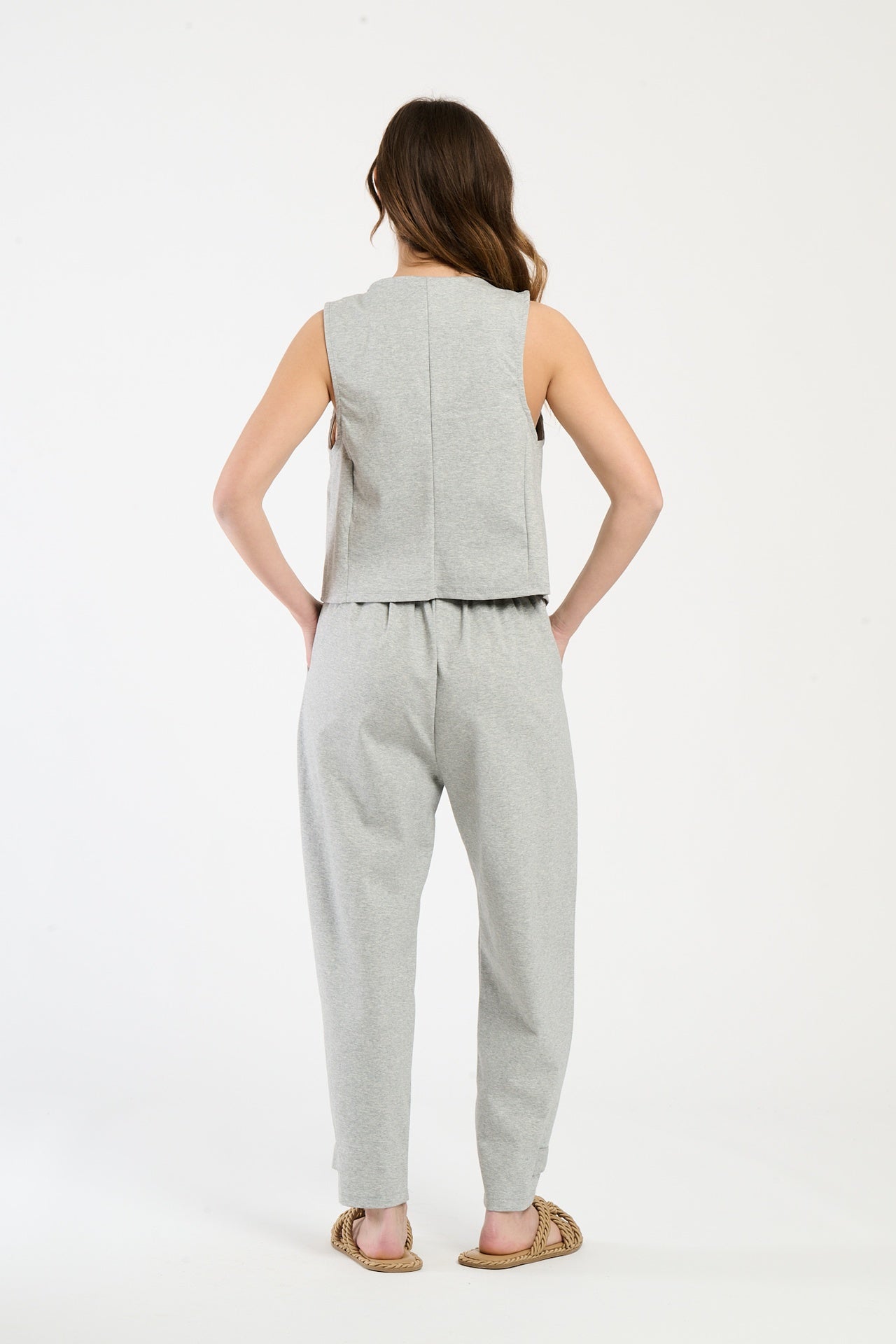 Completo grigio su una modella: gilet a bottoni e pantaloni, combinazione versatile e accattivante.