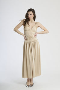 Abito lungo beige con scollatura a V profonda, silhouette dritta e gonna fluttuante.