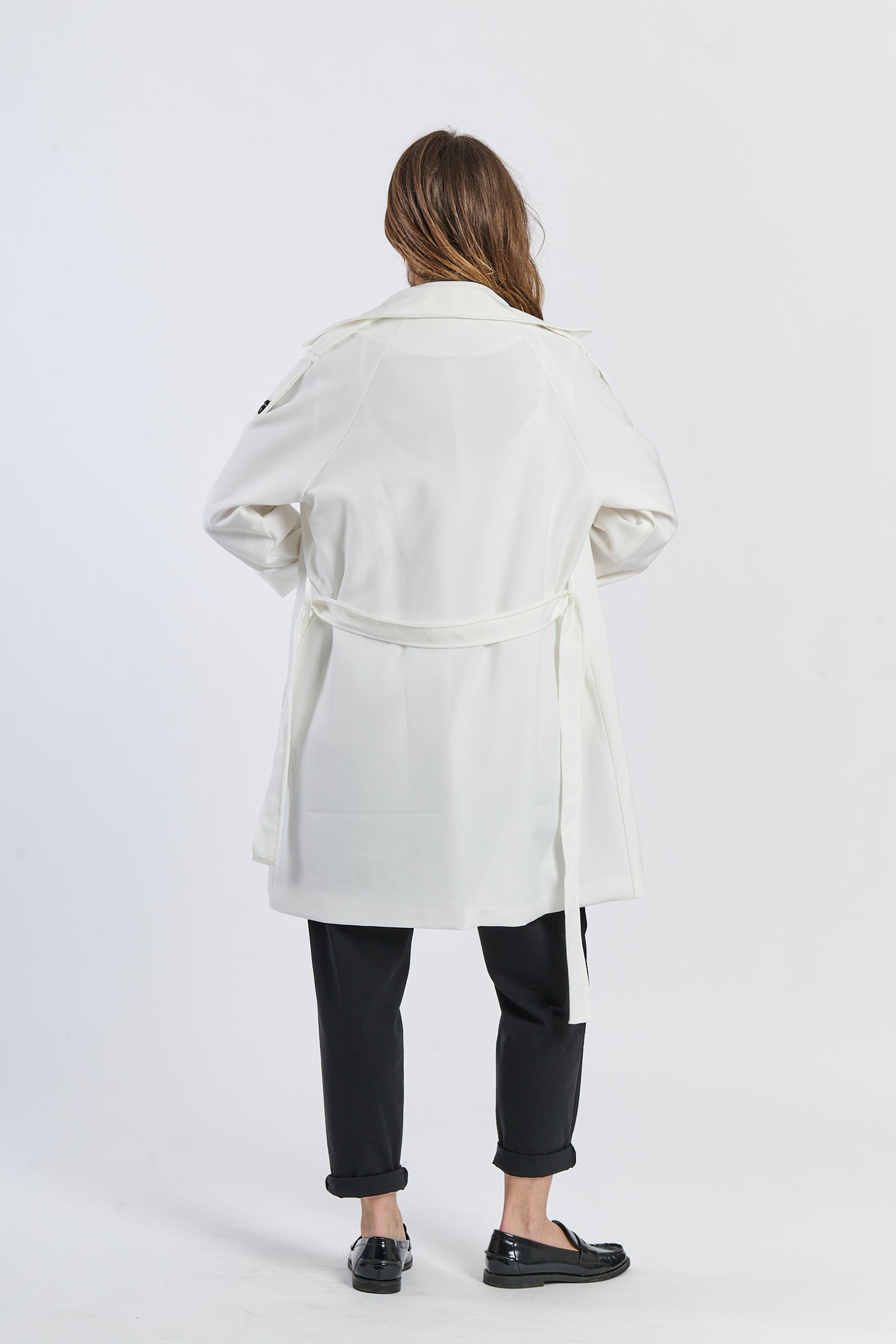 Trench bianco minimalista, tessuto leggero per l’estate urbana.