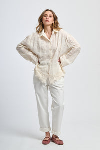 Look con maglia rosa scura e pantaloni grigi slim, accessoriato con una cintura nera, eleganza contemporanea.