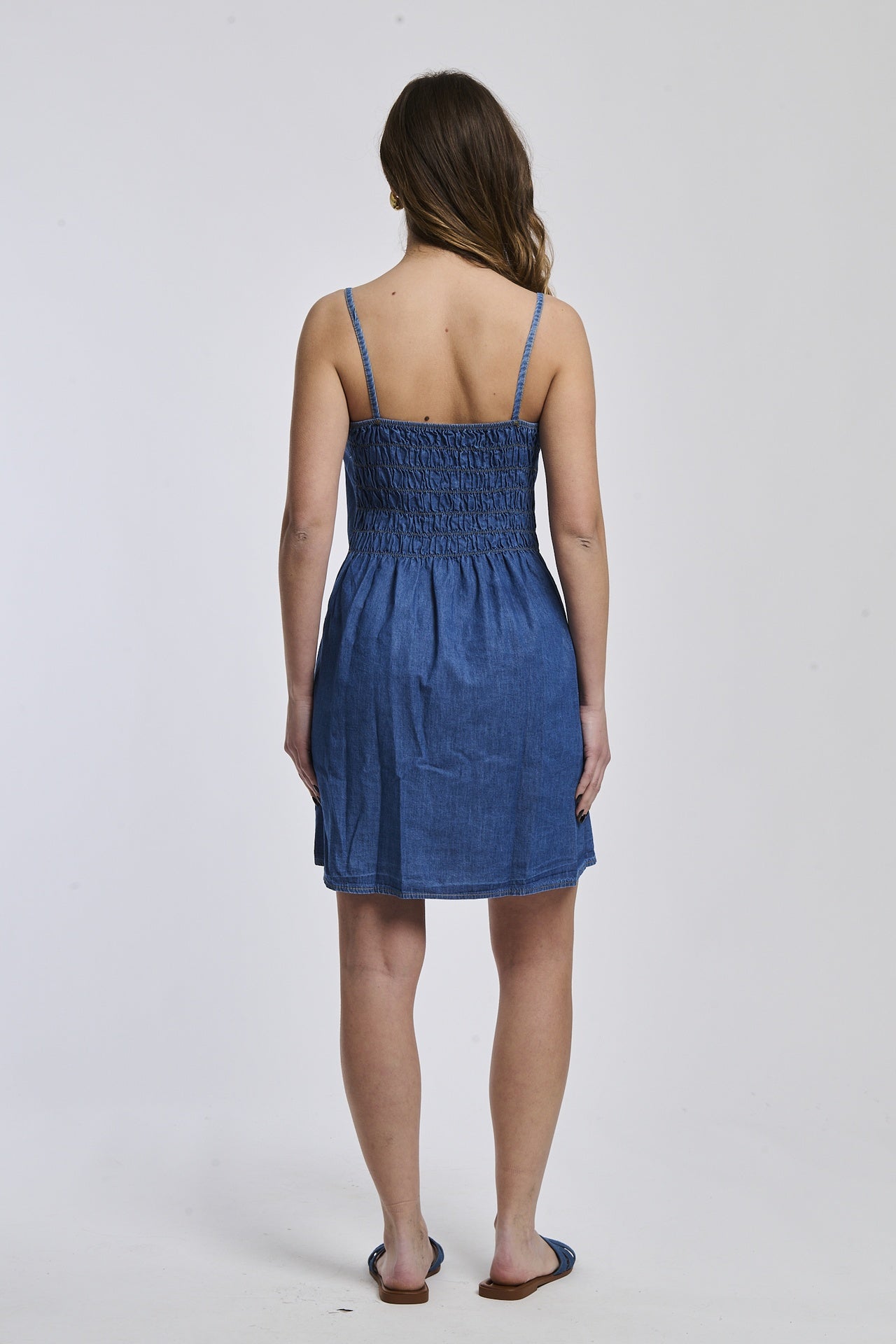 Abito denim con bottoni, silhouette dritta, spalline sottili, ideale per un look giovane.